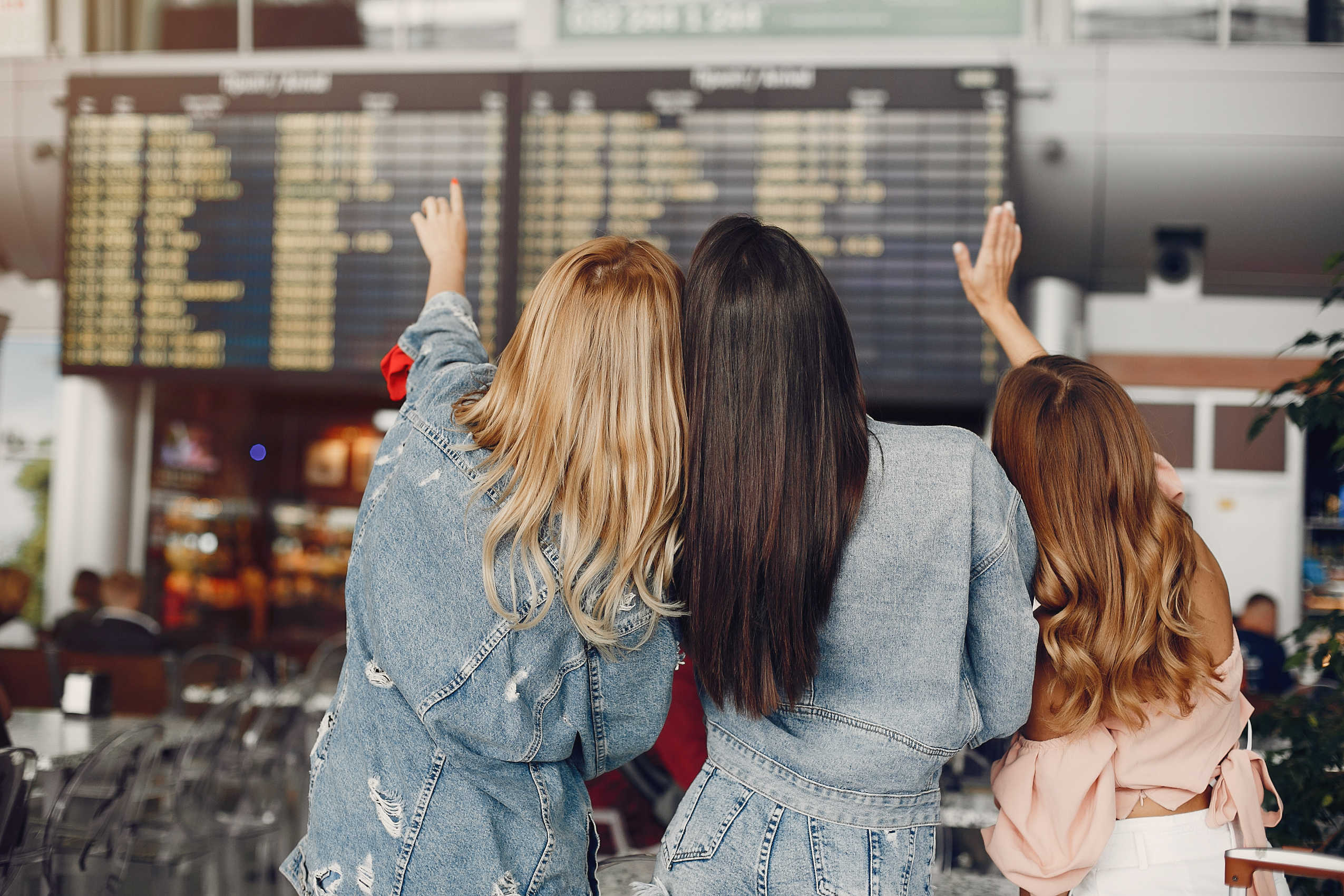 ragazze che guardano il tabellone degli arrivi e delle partenze all'aeroporto di treviso
